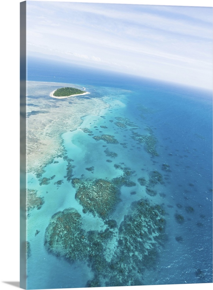 Clear blue tropical water, Green Island and Great Barrier Reef from above by helicopter