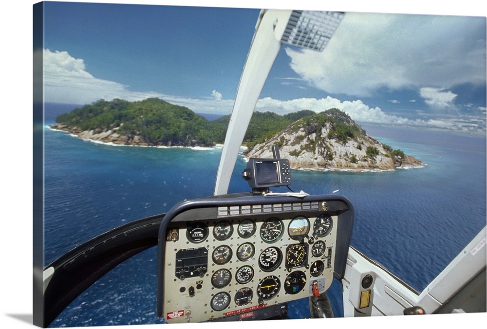 Africa, Seychelles, North Island, Tropical island seen from cockpit of helicopter flying towards the island, control scree...