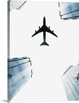 Airplane flying above skyscrapers