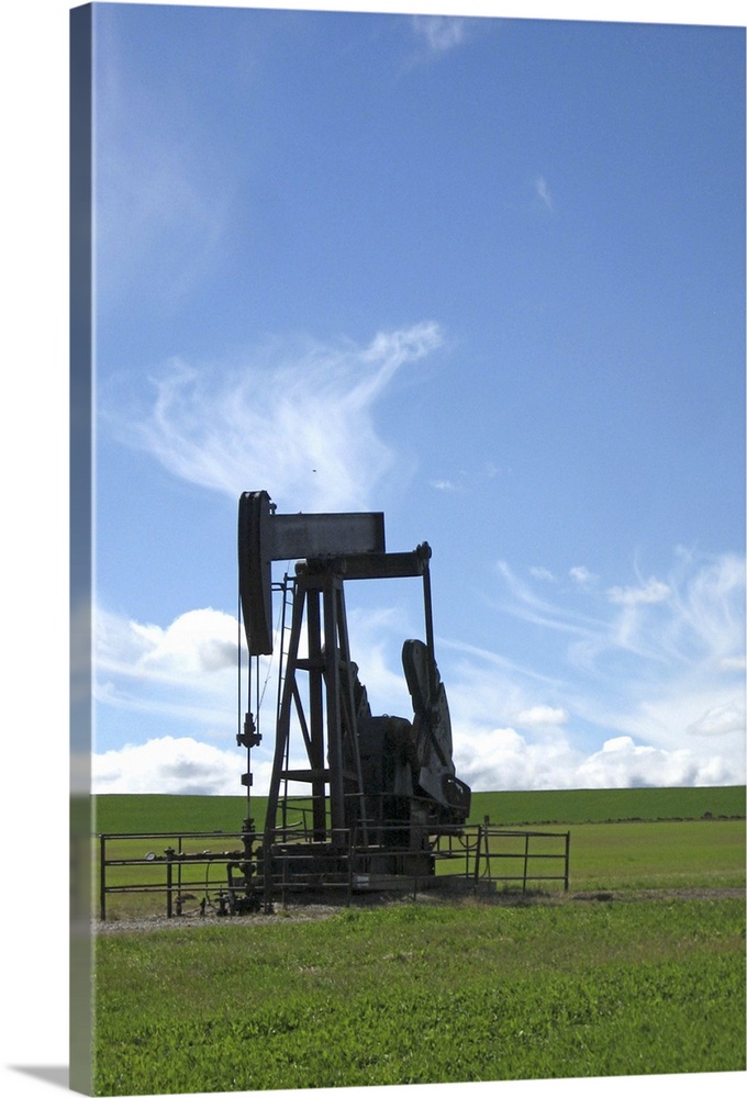 An oil pumpjack stands alone in a prairie field in Southern Alberta.
