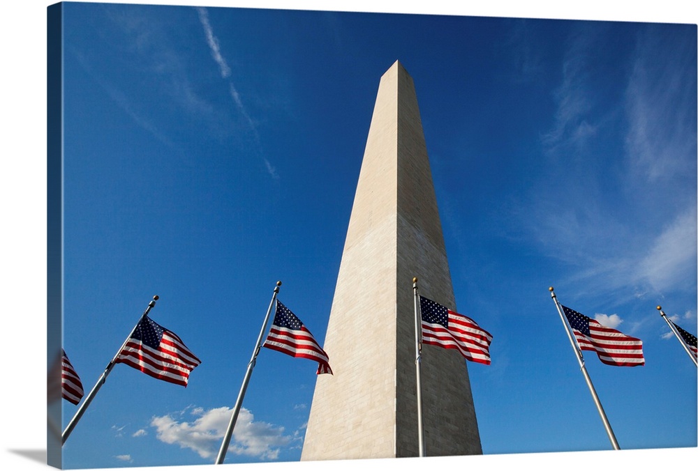 Low angle view of American flags at base of Washington Monument at sunset on summer evening, Washington, DC.
