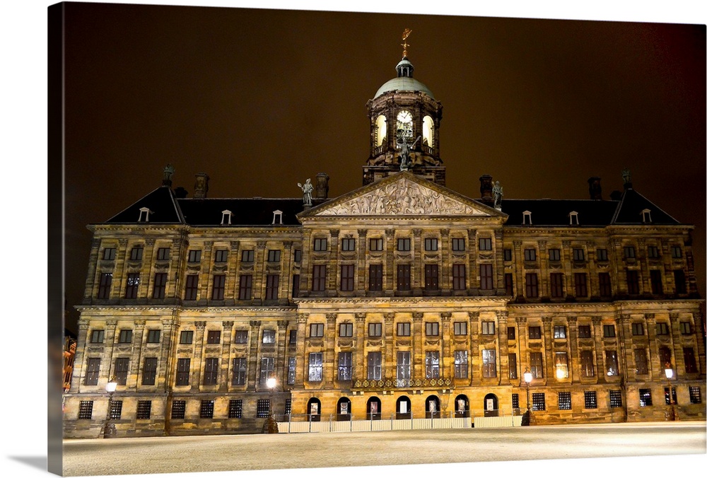 Royal Palace of Amsterdam illuminated at night with no people on Dam Square. National landmark, symbol of Dutch culture an...
