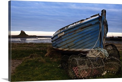 An Abandoned Boat And Traps On Shore With A View Of Lindisfarne (Holy Island)