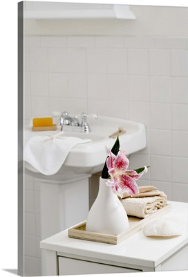 An orchid flower in a white vase in the bathroom