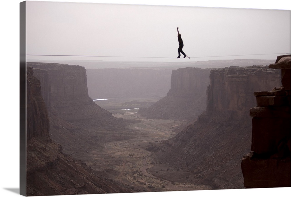 Andy Lewis working on a world record highline, three hundred and forty feet long, at the Fruit Bowl in Moab, Utah, USA.
