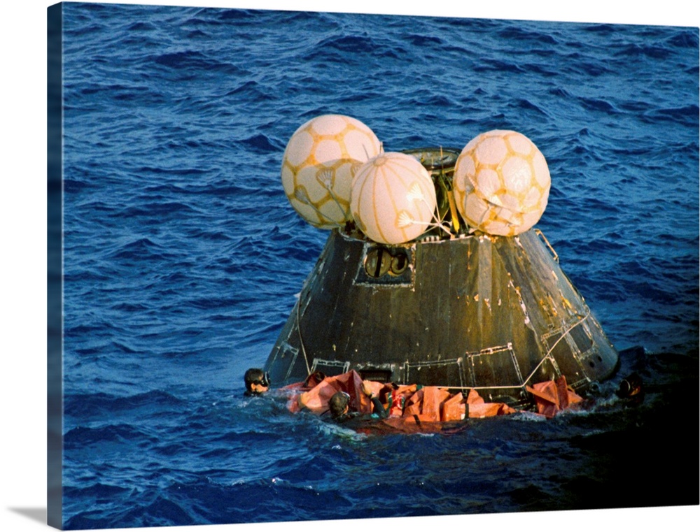 Navy swimmers fasten a floatation collar around the Apollo 13 capsule as it floats after splashdown in the Pacific Ocean. ...