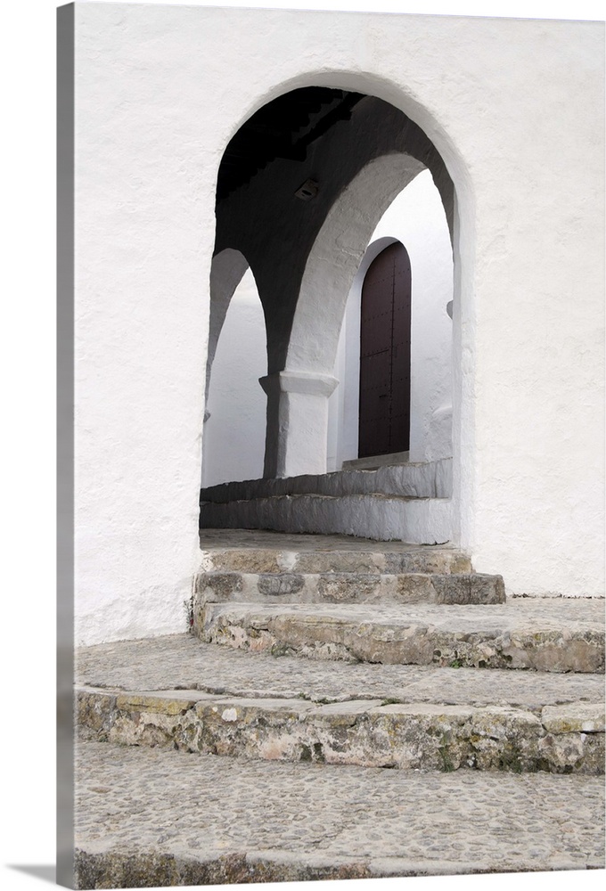 Steps leading up to the arched entrance to the inner courtyard and the main door of the ancient church of Puig de Missa, S...