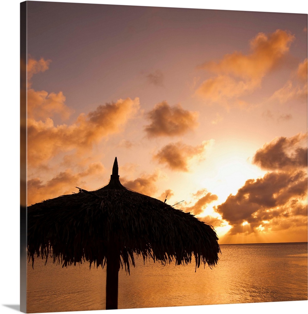 Aruba, silhouette of palapa on beach at sunset