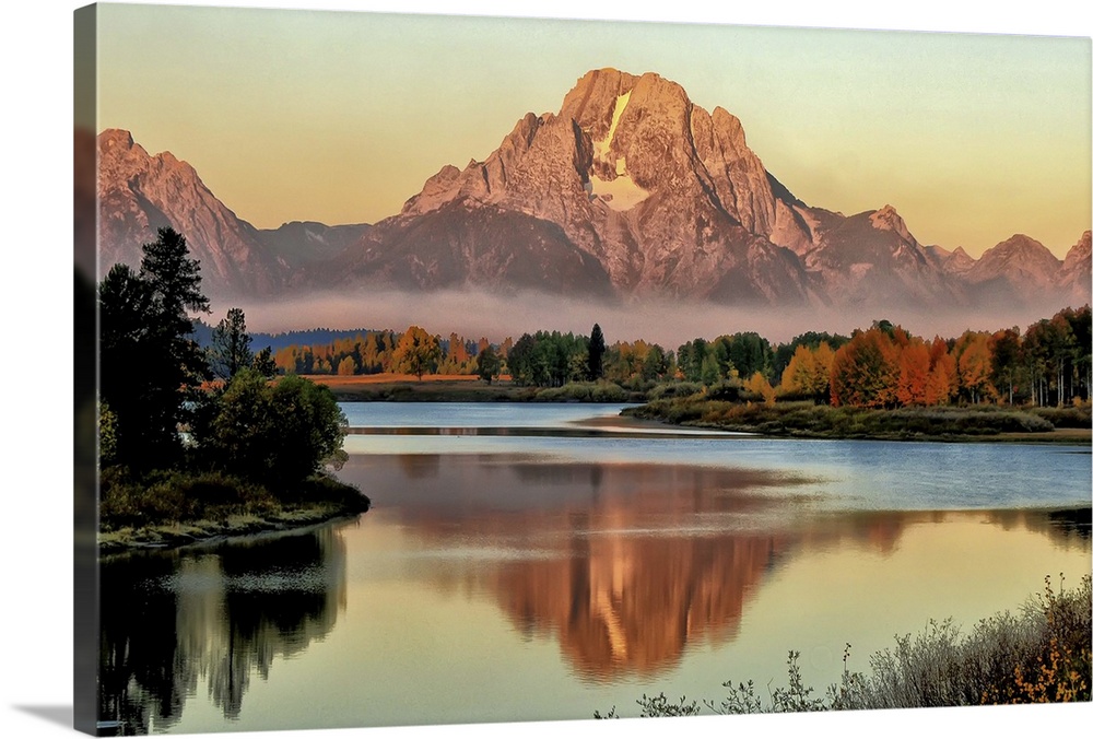 Smoke clouds from a nearby forest fire linger at the base of Mt Moran in Grand Teton National Park during the autumn seaso...