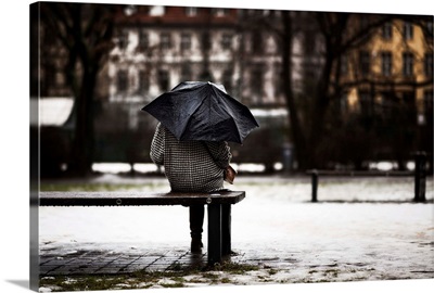 Back of woman with umbrella sitting in the rain