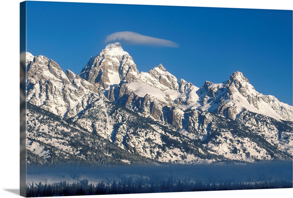 Banner cloud on summit of Grand Teton above fog layer in stable air above Snake River. View of Teton Range from Jackson Hole.