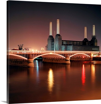 Battersea Power Station at night with light reflections in river Thames.