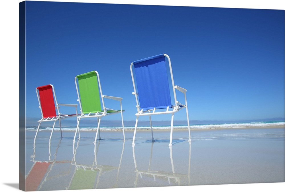 Red, green and blue beach chairs at the seaside. Pristine beach and blue sky. Eyre Peninsula. South Australia.
