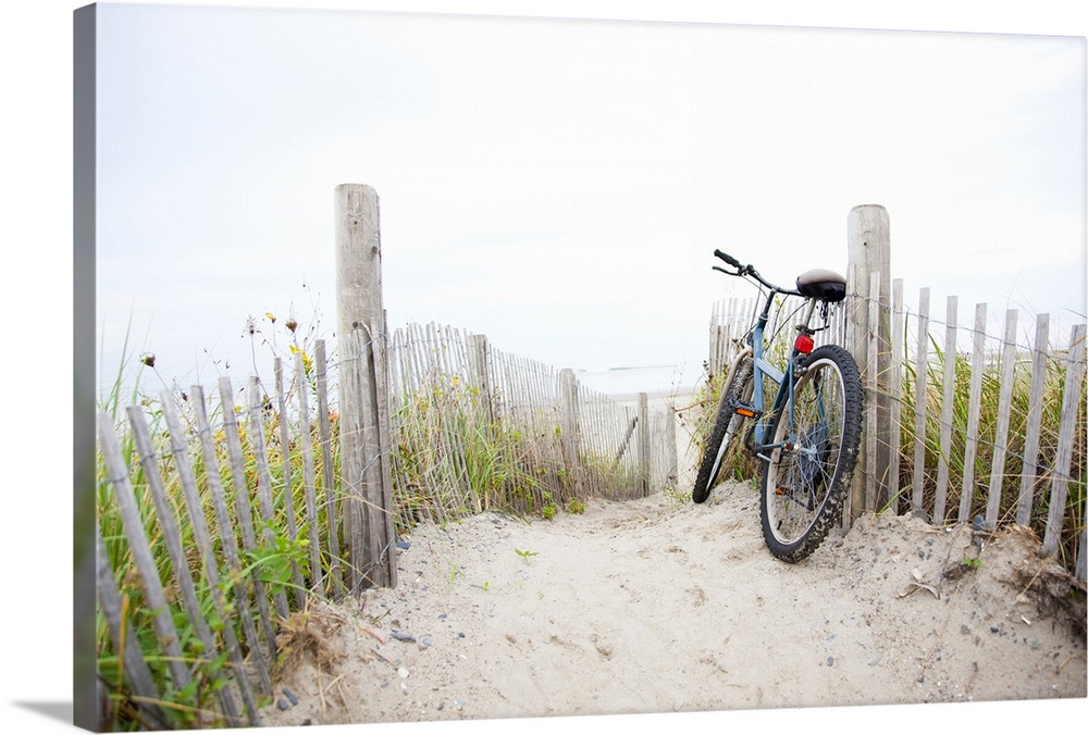 Bicycle leaning on beach fence