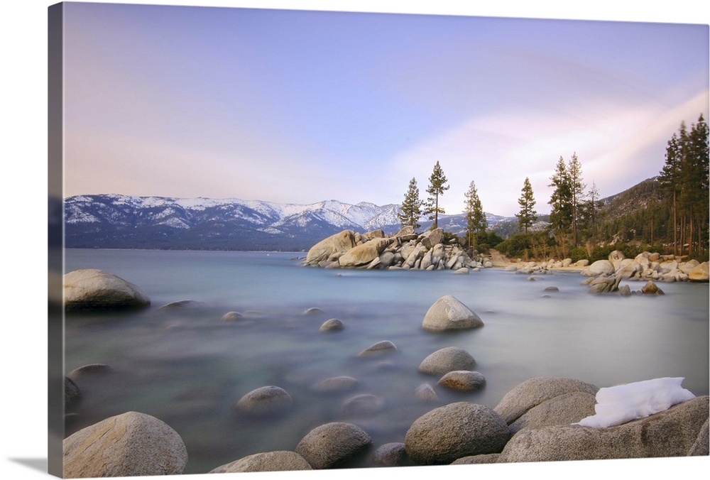 Beautiful landscape with rocks and water against mountains in background.
