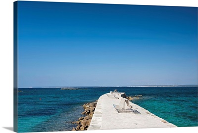 Blue mediterranean Beach of Es Trenc with pier and sitting bench.