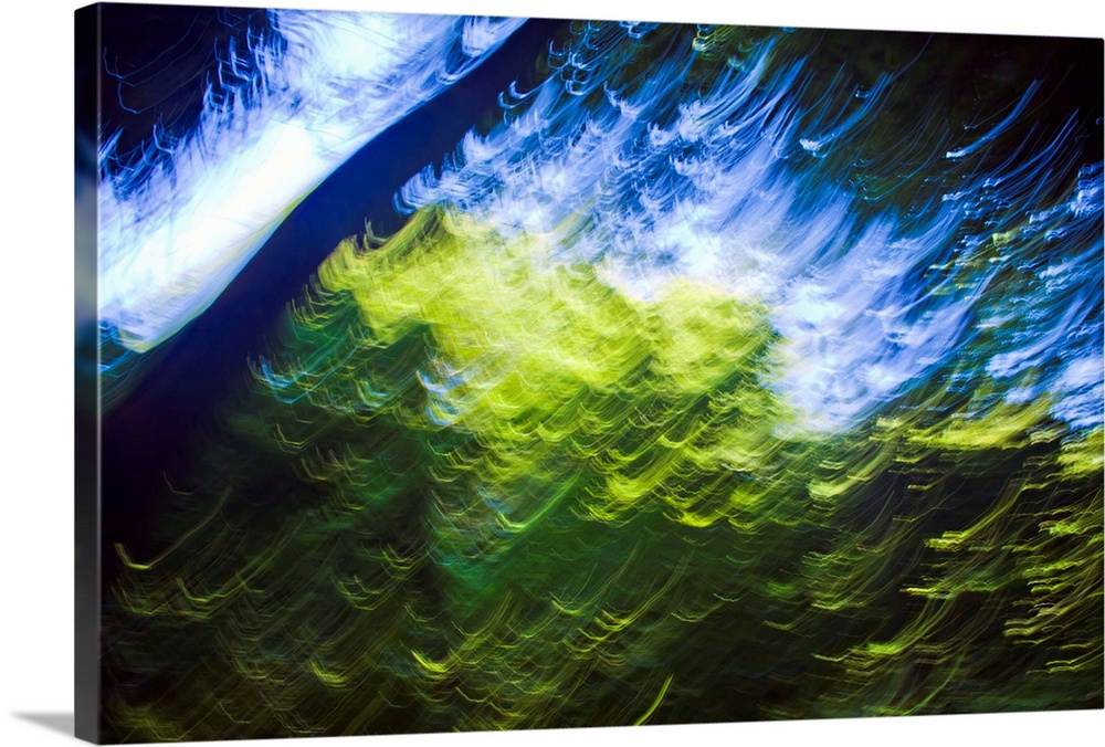 Blue sky seen from inside forest. Blurred motion. Sunlight on green leaves. Painterly effect. Could represent Imagination,...