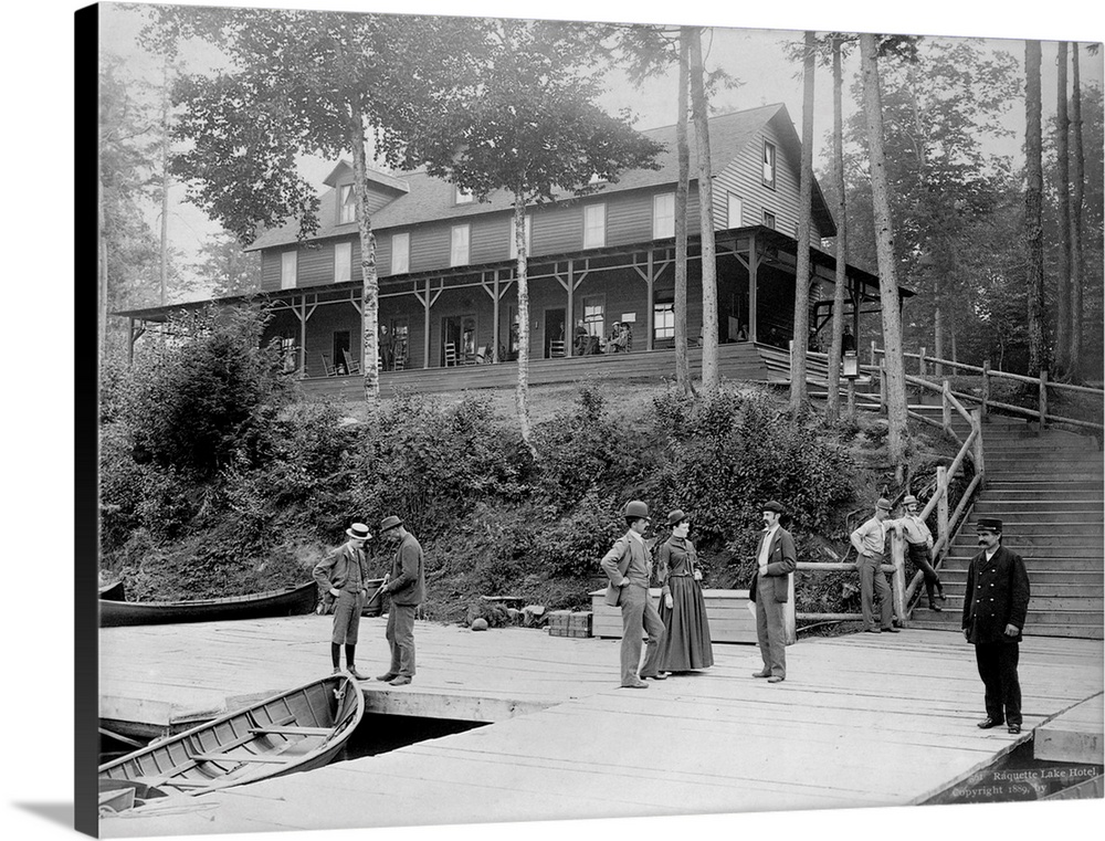 Boaters vacationing in the Adirondack Mountains talk on the pier at the Raquette Lake Hotel. Ca. 1889. | Location: Raquett...