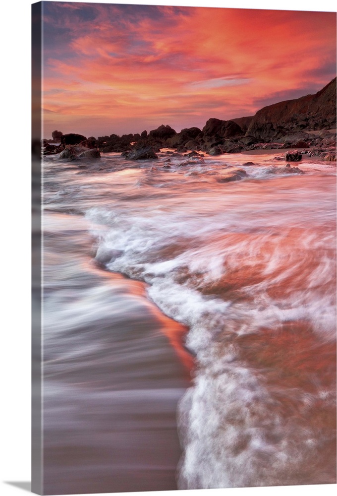 Bodega Bay, California water, rocks and cliffs are basked in color from exceptional sunset.