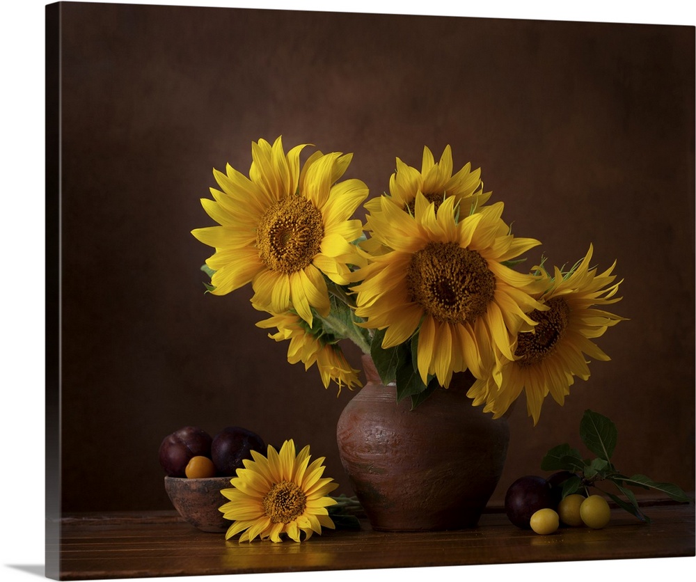 Bouquet of sunflowers in old clay jug with ripe cherry plum branches in the foreground.