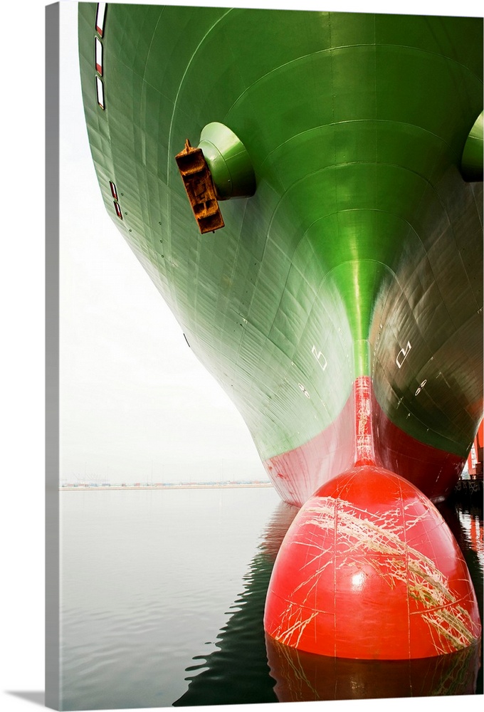 Bow of a red and green cargo ship.