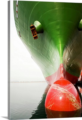 Bow of a red and green cargo ship.
