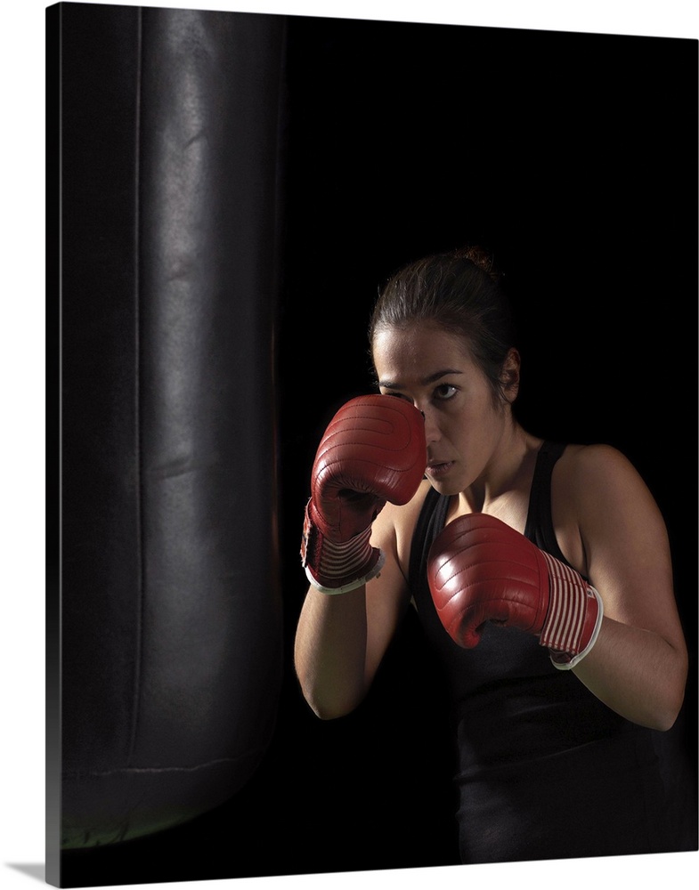 Female boxer training on punching bag