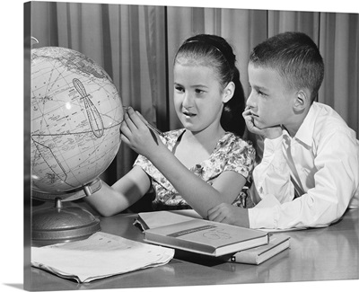 Boy and girl looking at globe