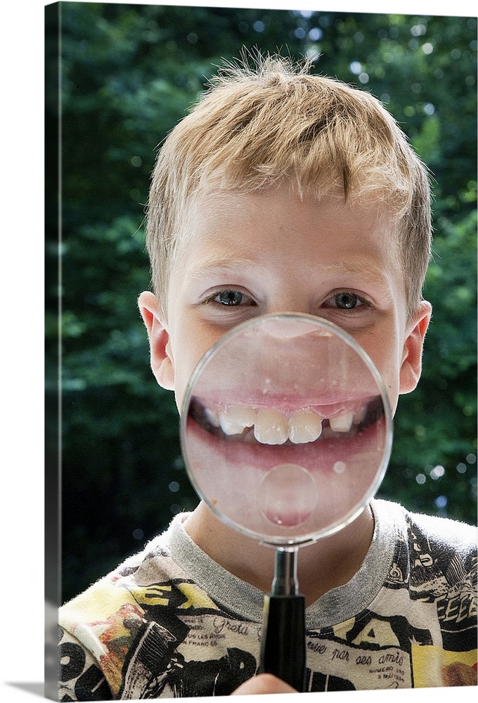 blond boy behind magnifying glass smiling