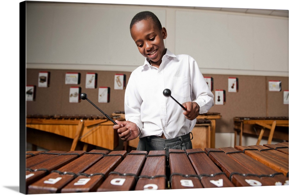 Boy playing wooden xylophone in classroom, Johannesburg, Gauteng Province, South Africa.