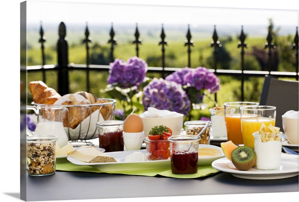 A spread of breakfast food is photographed on a table that sits on an outdoor terrace