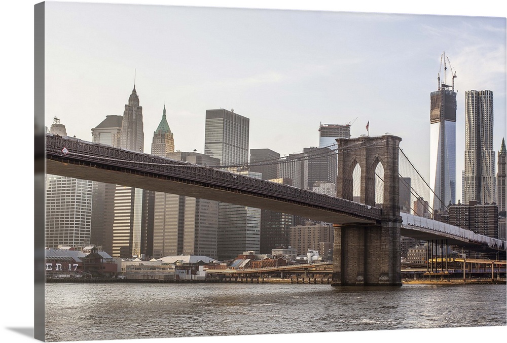 A shot of Brooklyn Bridge with the New York City skyline in the background, including the One World Trade Center.