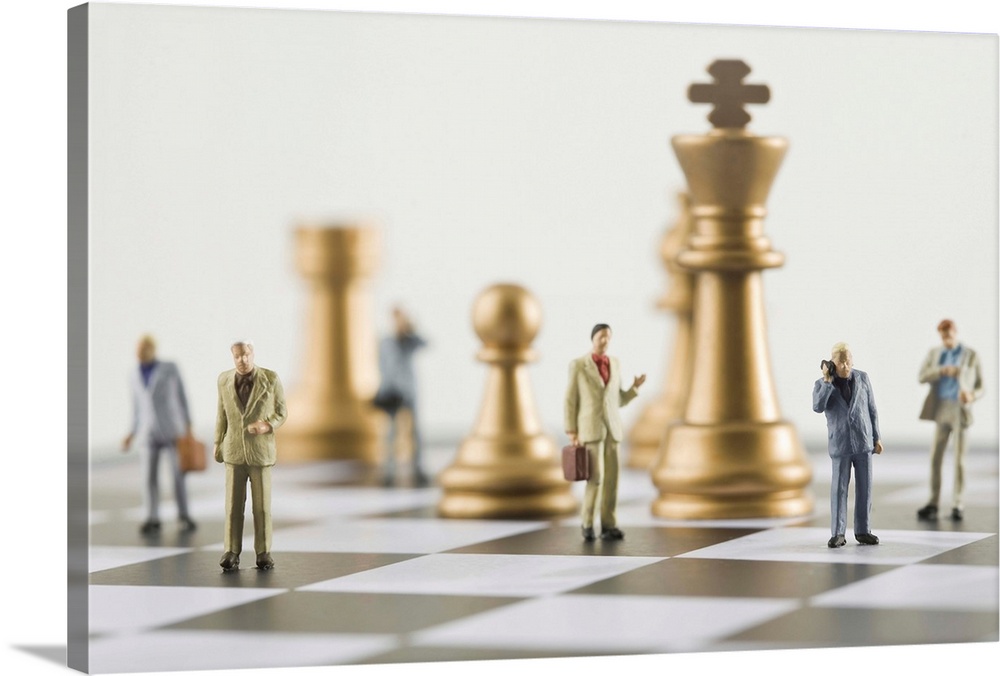 Businessmen figurines standing a top chess board (focus on foreground)