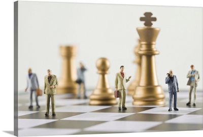 Businessmen figurines standing a top chess board