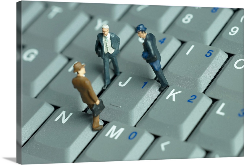 Businessmen figurines standing on a computer keyboard