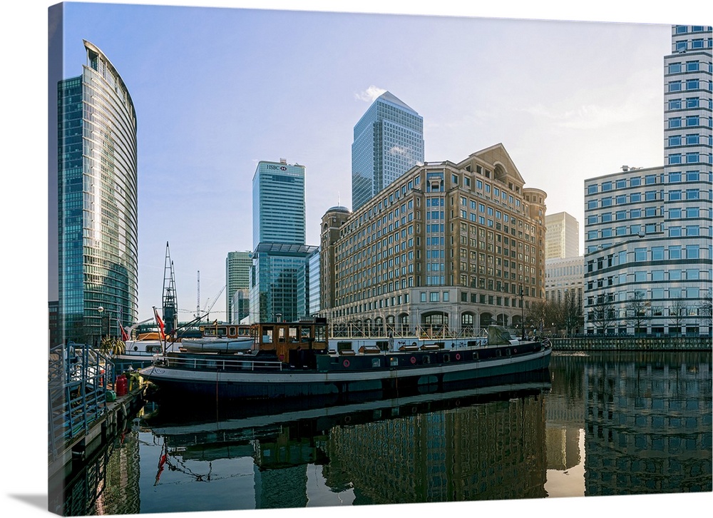 Canary Wharf and barges in early morning light as seen from West India Quay