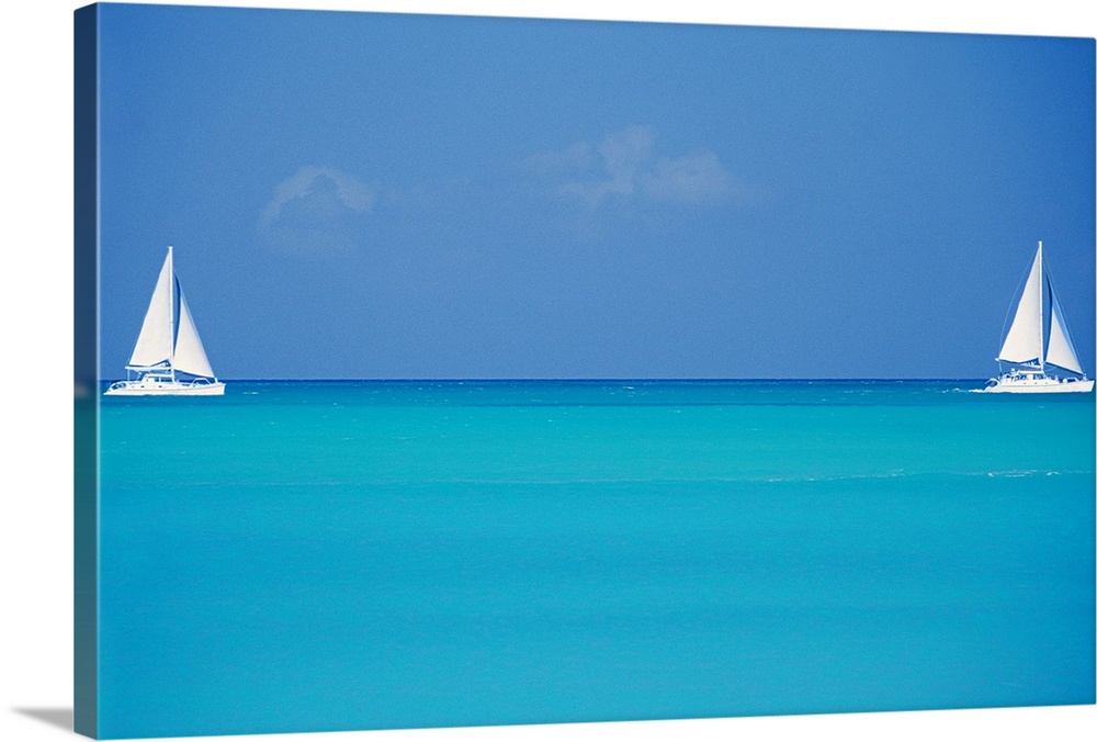 Canvas print of two sailboats floating in clear ocean water with one on the left and one on the right.