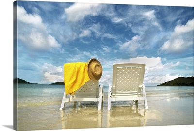 Chairs on beach with towel and hat