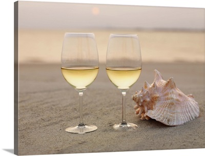Champagne glasses and a shell on the beach