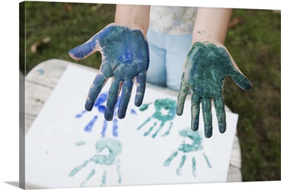 Child with handprint painting and paint on hands