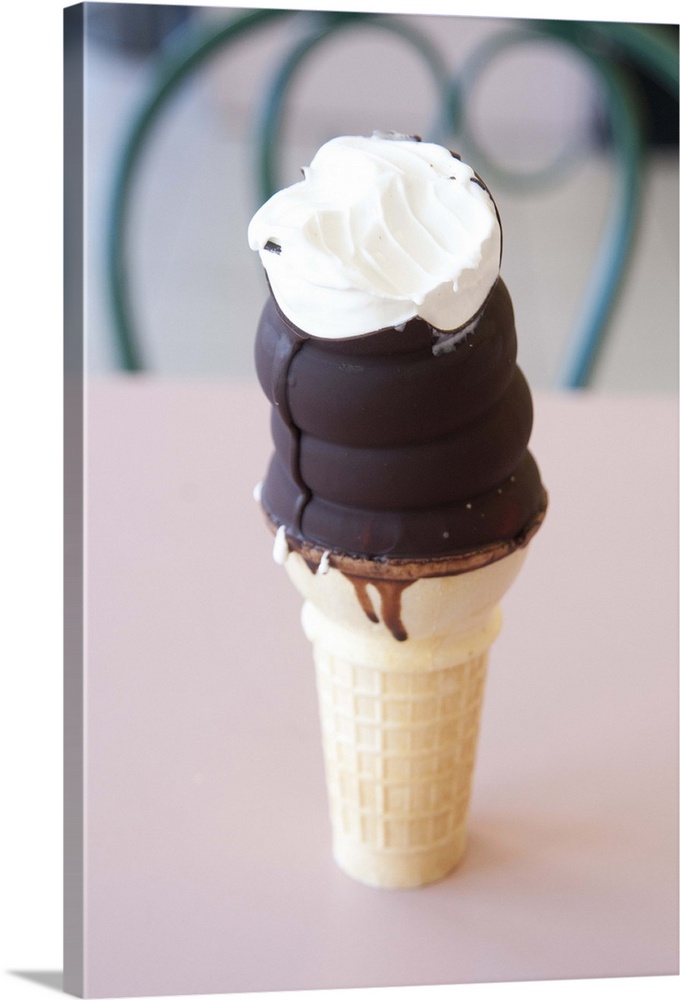 Chocolate dipped ice cream cone with one bite out of it.
