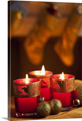 Christmas candles with stockings hung in the backg