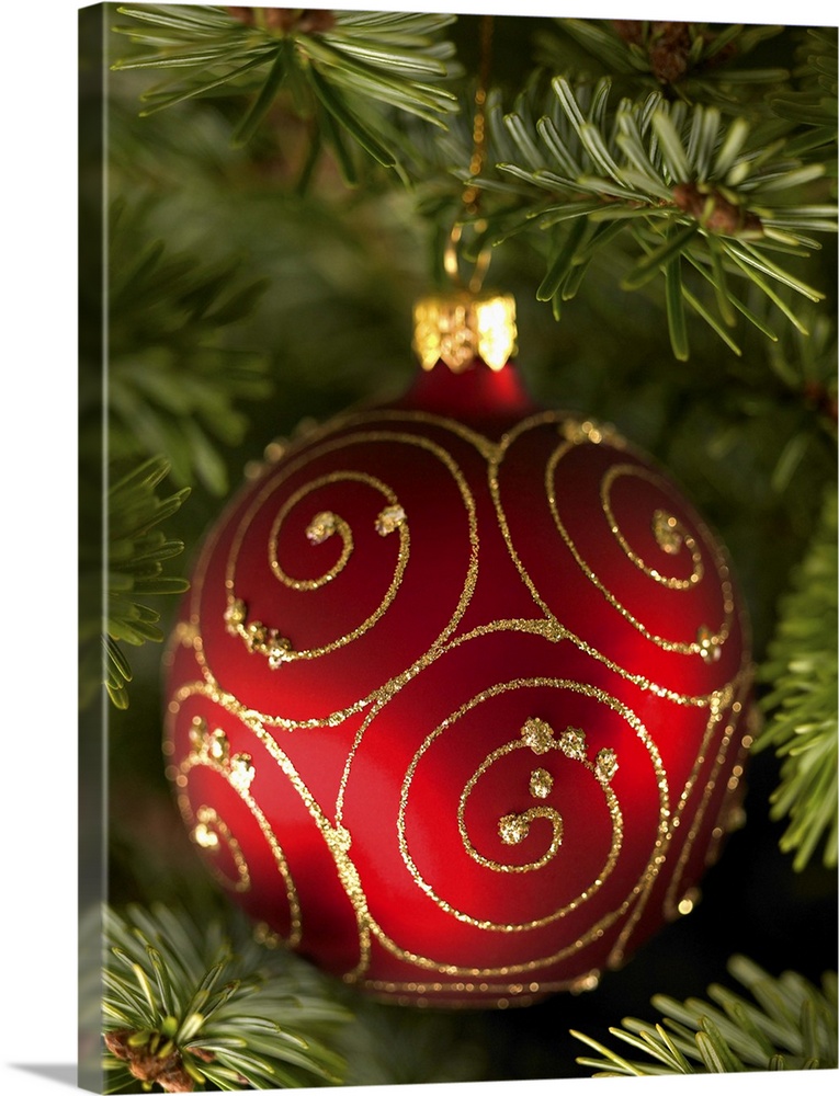 Red bauble decoration hanging on Christmas tree.
