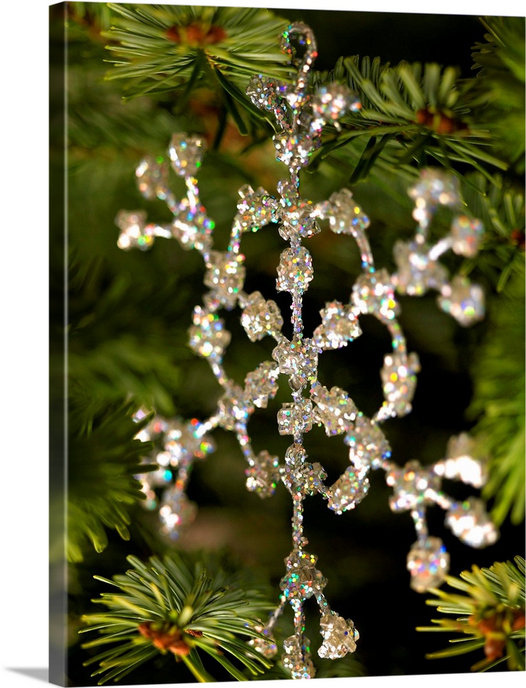 Glass snowflake decoration hanging on Christmas tree.