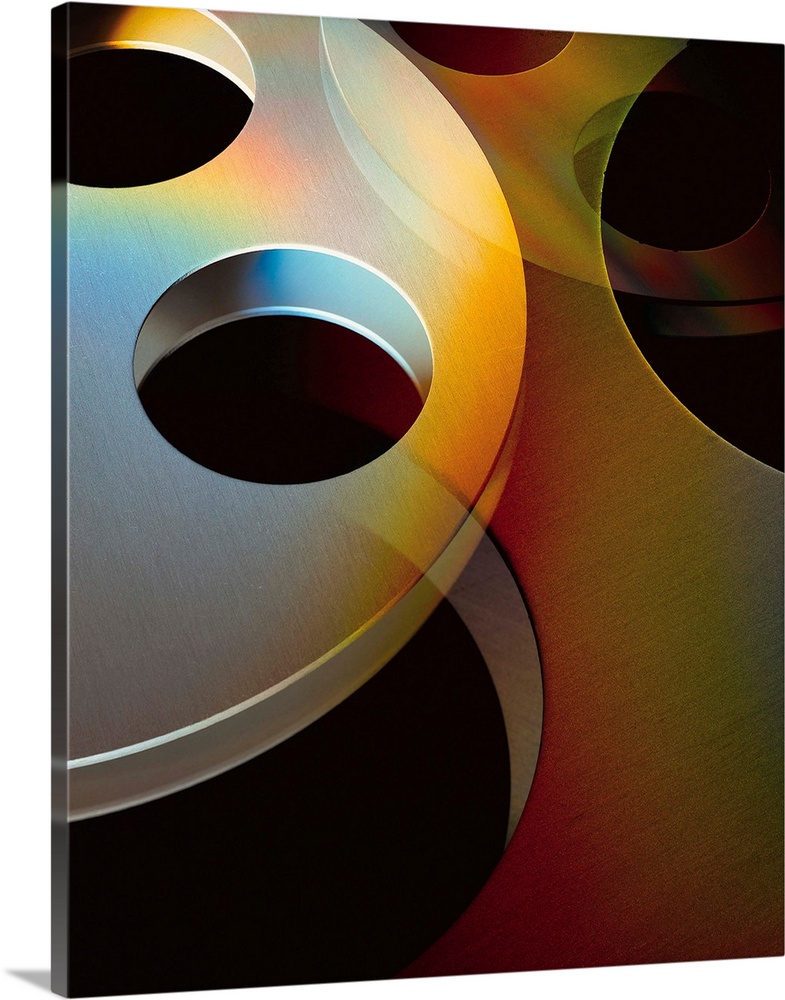 circular movie reels lie on top of each other in front of a black background
