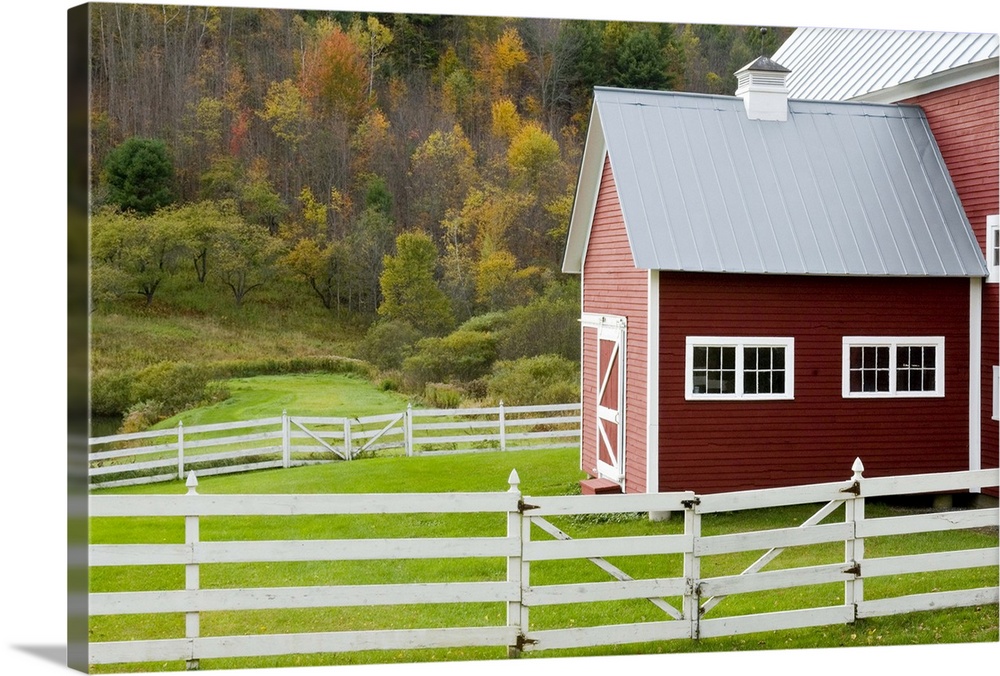 Classic New England farm with red barn and white fence. Vermont. USA