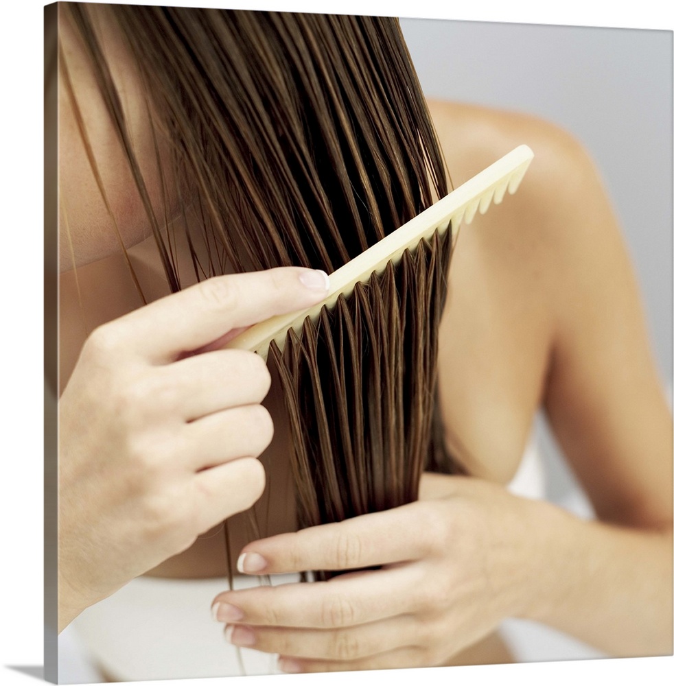 Close-up of a woman combing her wet hair