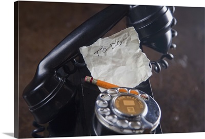 close-up of antique telephone with pencil and 'to do' list