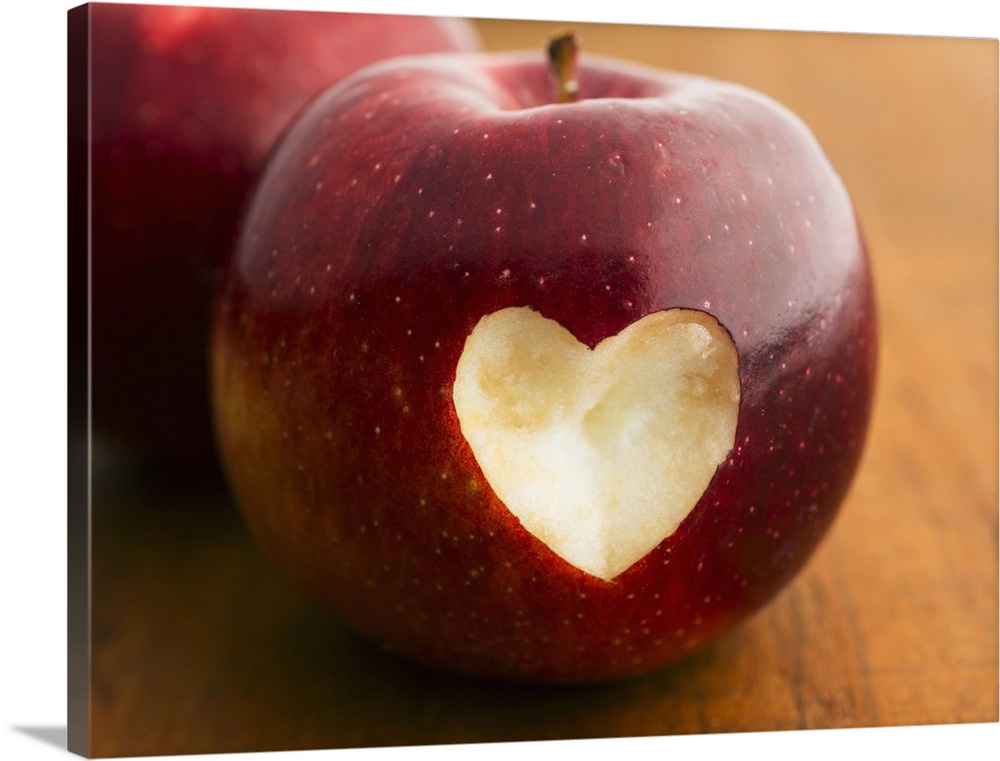 Close up of apple with missing bite in heart shape, studio shot