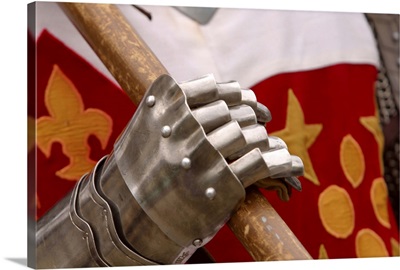 Close-up of articulated hand of armor gripping weapon